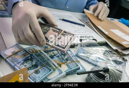 Spezialisierter Polizist notiert Dollar Banknote Referenz eines Raubes, konzeptuelle Bild Stockfoto