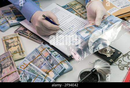 Spezialisierter Polizist notiert Dollar Banknote Verweis auf einen Raub in kriminelle Ermittlungseinheit, konzeptionelles Bild Stockfoto