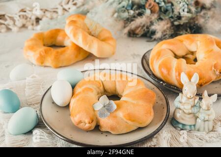 Hausgemachte osterbrötchen auf einem Tisch, der zum osterbrunch dekoriert ist Oder Frühstück Stockfoto