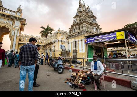 Mysuru, Karnataka, Indien - 2019. Januar: Ein Straßenhändler, der Waren vor einem alten Hindu-Tempel im Mysore-Palast verkauft. Stockfoto