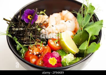 Sack Salat mit Garnelen in einer Schüssel. Zutaten Garnelen, blanchierten Spinat, Kirschtomaten, Reis, Gurke, soja-Ingwer-Sauce, würzige Sauce, Nori, Sesam Stockfoto