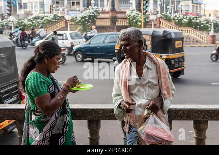 Mysuru, Karnataka, Indien - 2019. Januar: Ein alter Mann und eine Frau unterhalten sich auf einer belebten Straße in der Stadt Mysore. Stockfoto