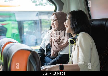 Zwei junge Frauen lachen, während sie miteinander plaudern Stockfoto