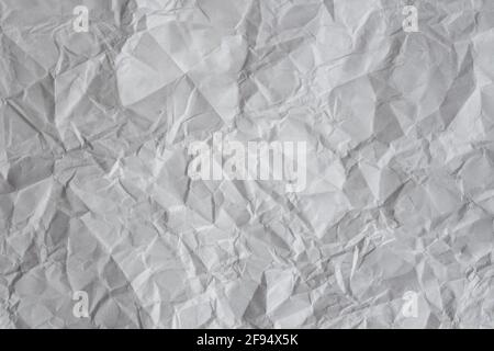 Grauer Hintergrund. Zerknitterter Papierbogen-Hintergrund. Leere, knitterte Papierstruktur. Stockfoto