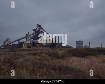 Das verlassene, verlassene Geschwulst des Hochofens am Redcar Steelworks gegen einen wolkenbetrübten Himmel, von den Dünen des Coatham-Sümpfes aus gesehen. Stockfoto