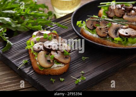 Sandwich mit Pilzen und Frischkäse auf einem rustikalen Holzhintergrund Nahaufnahme. Stockfoto