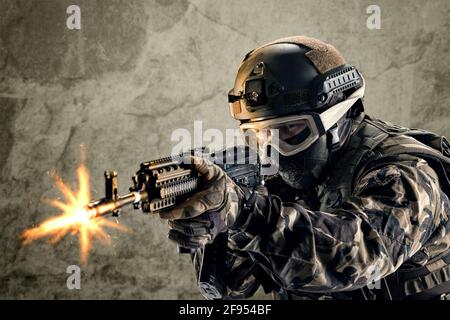 Der Soldat der Spezialeinheiten hält eine Waffe in den Händen und schießt ihn. Stockfoto