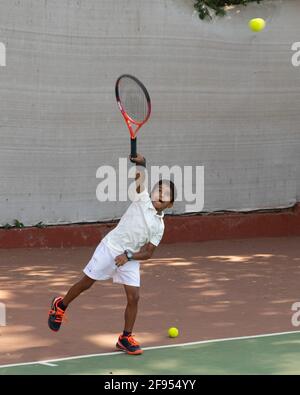 Kleine Kinder, die Tennisunterricht mit einem Trainer an der SPG (Shivaji Park Gymkhana) Tennis Academy in Mumbai, Maharashtra, Indien, haben. Stockfoto