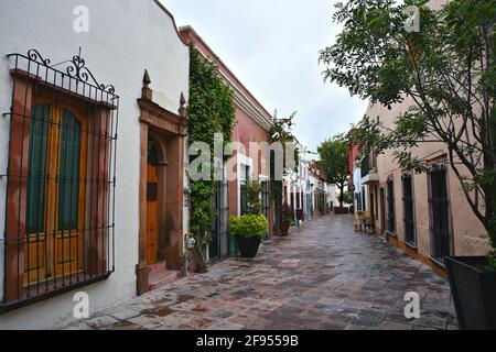 Kolonialbauten mit bunten Stuckfassaden an den Kopfsteinpflasterstraßen von Santiago de Querétaro in Mexiko. Stockfoto