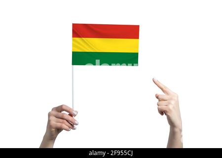 Eine schöne weibliche Hand hält eine bolivianische Flagge, auf der sie den Finger ihrer anderen Hand zeigt, isoliert auf weißem Hintergrund. Stockfoto