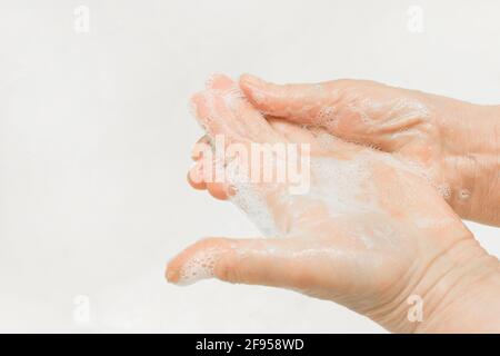 Die Hände einer erwachsenen Frau wurden mit Seife gewaschen, Nahaufnahme. Händewaschen und Haushaltshygiene-Konzept. Stockfoto