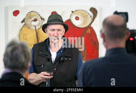 Mecklenburg-Vorpommern, Güstrow. 16. April 2021: Bei einem Pressetermin in der Wollhalle steht Alexander Dettmar, Maler, in seiner Ausstellung "Ich glaube an die Kraft der Farbe" vor seinem Gemälde "Musikclows", Öl auf Leinwand, 2018, und beantwortet Fragen von Journalisten. Die Ausstellung wird am 17.04.2021 eröffnet und wird wegen der Korona voraussichtlich nur bis 18.04.2021 für die Öffentlichkeit zugänglich sein. Der Schwerpunkt der 71 ausgestellten Gemälde liegt auf floralen Stillleben und Clownzeichnungen. Foto: Bernd Wüstneck/dpa-Zentralbild/dpa Quelle: dpa picture Alliance/Alamy Live News Stockfoto