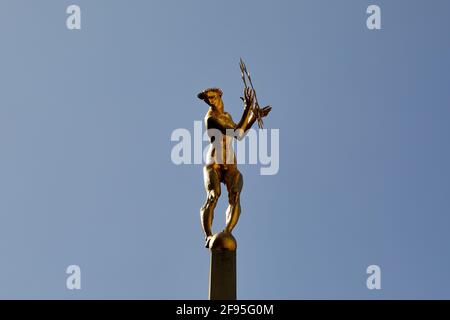 London, Großbritannien - 4. April 2021: Die vergoldete Bronzefigur von Helios, dem allsehenden Sonnengott der griechischen Mythologie, der den zentralen Innenhof des Fernsehzentrums in White City schmückt. Die Statue, die vom Bildhauer T B Huxley-Jones entworfen wurde, wurde für den ehemaligen BBC-Sender, der 1960 eröffnet wurde, in Auftrag gegeben. Die Statue stellt die Ausstrahlung des Fernsehlichts auf der ganzen Welt dar und sitzt in der Mitte eines Brunnens und zwei liegende Figuren, die Ton und Vision repräsentieren, die beiden Komponenten des Fernsehens. Stockfoto