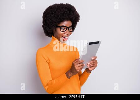 Foto-Porträt der staunenden afro amerikanische Frau hält Tablet in Zwei Hände isoliert auf hellgrauem Hintergrund Stockfoto