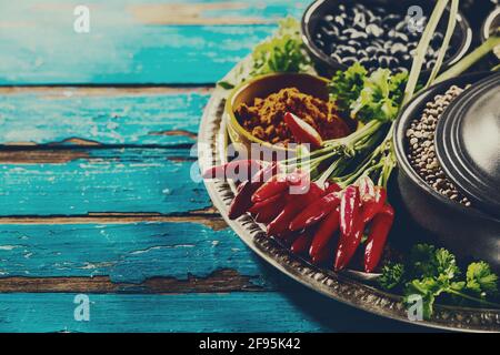 Schöne leckere appetitliche Zutaten Gewürze Lebensmittelgeschäft für das Kochen gesunde Küche. Blauer Alter Holzhintergrund Draufsicht. Stockfoto