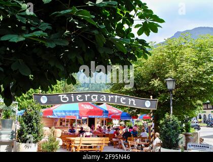 Berchtesgaden, Deutschland: Ein traditioneller deutscher Biergarten in Bayern. Regenschirme mit der Aufschrift „Hofbrauhaus Berchtesgaden“ Stockfoto
