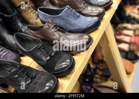 Herrenschuhe auf den Holzregalen in einem Geschäft Stockfoto