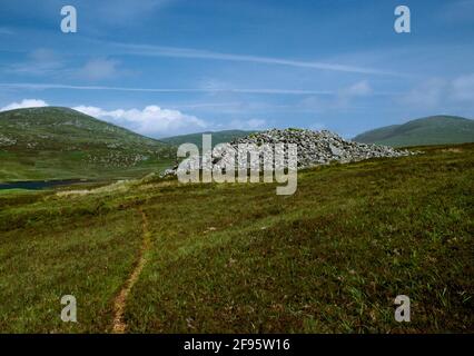 Ansicht E von Reineval (Reineabhal) Neolithischer Rundkahn, South Uist, Schottland, UK: Aufrechte Platten des Peristaliths ragen aus dem Cairn. Stockfoto