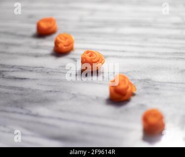 Reihe von Karottenrosen auf weißem Marmor Stockfoto