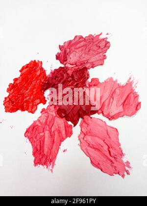 Pinkfarbener, roter, burgunderroter Lippenstift auf weißem Hintergrund. Stockfoto