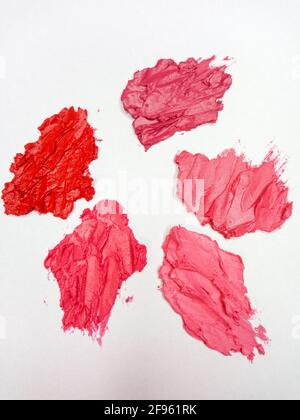 Pinkfarbener, roter, burgunderroter Lippenstift auf weißem Hintergrund. Stockfoto