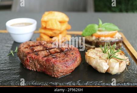 Köstliches Medium Well Grilled Filet Mignon Steak mit gegrilltem Gemüse Auf heißer Steinplatte Stockfoto