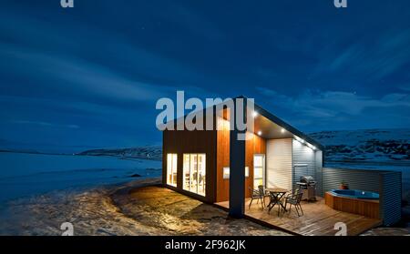 Beleuchtetes Ferienhaus in Island im Winter Stockfoto
