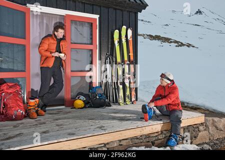 Pärchen, die sich für Skitouren im Ski Cottage in vorbereiten Island Stockfoto