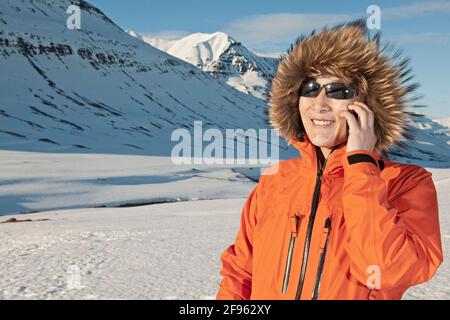 Frau im Gespräch auf ihrem Smartphone in Island Stockfoto