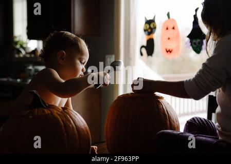 Zwei Kinder Kürbis schnitzen an halloween in ihrem Zuhause Stockfoto