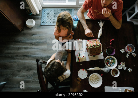Die Familie macht Lebkuchenhäuser zusammen zu Hause Stockfoto