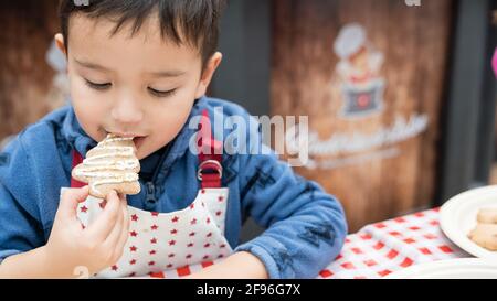 Kinder backen zu Weihnachten, Kinderbäckerei, Junge essen Plätzchen Stockfoto