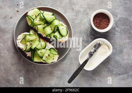 Sandwiches mit Frischkäse und Gurke auf einem grauen Tisch. Stockfoto