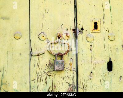 Antikes Vorhängeschloss an einer alten grünen Holztür Stockfoto