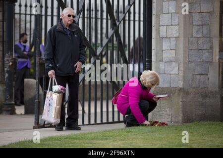 London, Großbritannien. April 2021. Nach dem Tod des britischen Prinzen Philip, Herzog von Edinburgh, der im Alter von 99 Jahren starb, hinterlässt eine Frau im Schloss Windsor Blumen. (Foto von Yunus Dalgic/SOPA Images/Sipa USA) Quelle: SIPA USA/Alamy Live News Stockfoto