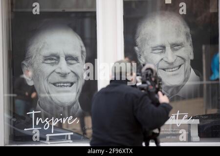 London, Großbritannien. April 2021. Ein Kameramann nimmt einige der schwarz-weißen Portraits des Prinzen Philip auf, die in einem Geschäft gegenüber von Windsor Castle ausgestellt sind. Prinz Philip starb am 9. April im Alter von 99 Jahren. (Foto von Yunus Dalgic/SOPA Images/Sipa USA) Quelle: SIPA USA/Alamy Live News Stockfoto