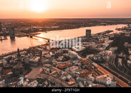Riga Panorama auf der Dachterrasse bei Sonnenuntergang mit städtischen Architekturen und Daugava Fluss. Stockfoto