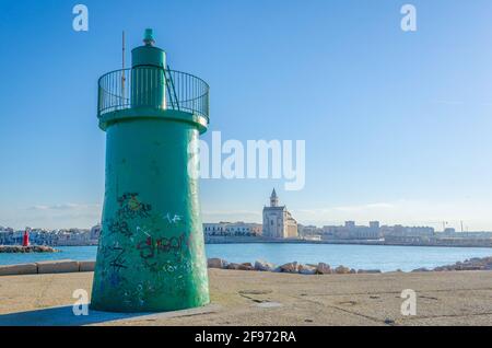 Blick auf die berühmte Basilika cattedrala di san nicola pellegrino hinter einem Leuchtturm in der italienischen Stadt Trani. Stockfoto