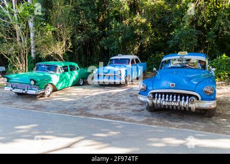 VINALES, KUBA - 18. FEBRUAR 2016: Alte Taxis am Eingang zur Cueva del Indio Höhle im Vinales Tal, Kuba Stockfoto