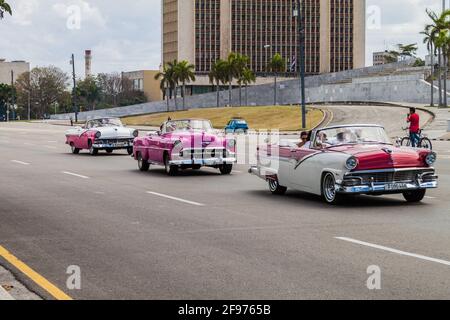 HAVANNA, KUBA - 21. FEB 2016: Bunte Oldtimer bringen Touristen auf ihre Stadtrundfahrt. Plaza de la Revolucion. Stockfoto