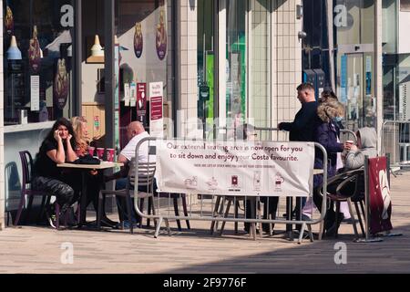 Menschen im Costa Coffee genießen einen Kaffee im Sitzbereich im Freien. Erster Freitagnachmittag, Ende der Sperre. Stockfoto