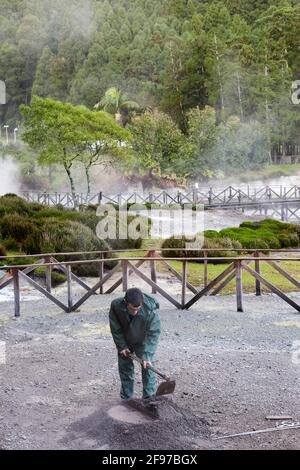 Ein Mann, der ein Loch in Fumarolis da Lagoa das Furnas für Cozido das Furnas auf der Insel Sao Miguel auf den Azoren, Portugal, grub Stockfoto