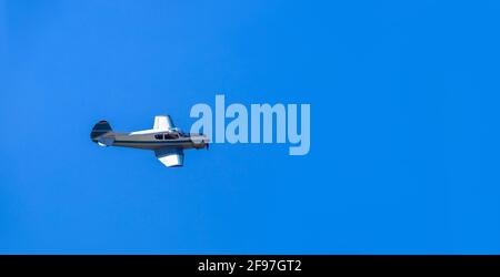 Ein kleines Charterflugzeug mit einem Propeller fliegt auf privaten Geschäftsflügen am klaren blauen Himmel, niemand. Stockfoto