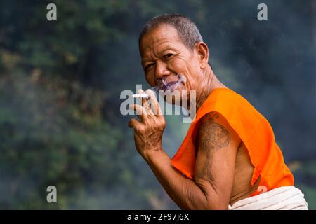 Laos, Luang Prabang, der Tempel VAT Xieng Mene Saiyasettharam, Mönch, Rauchen, Stockfoto