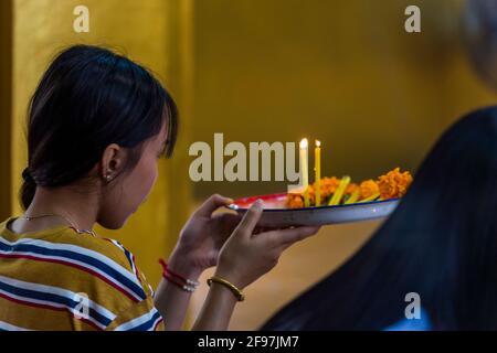 Laos, Vientiane, der VAT Simuang Tempel, Frau, beten, Tablett, Kerzen Stockfoto