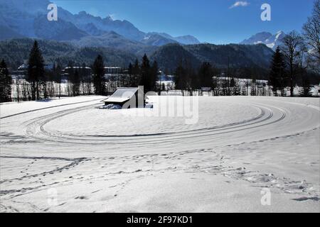 Langlaufloipe im Schloss Elmau Luxury Spa Retreat & Cultural Hideaway im Elmauer Tal zwischen Garmisch-Partenkirchen und Mittenwald. Rundkurs, Endlosschleife, Winter im Werdenfelser Land, Alpspitze, Wettersteingebirge, Europa, Deutschland, Oberbayern, Elmau, Klais, Krün bei Mittenwald, Traumwetter, Spuren im Schnee Stockfoto