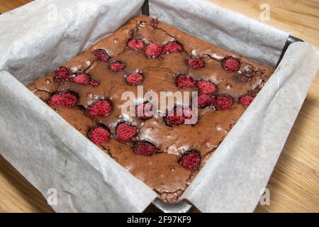 Ein frisch gebackenes Tablett mit Himbeeren in Schokolade Brownies A Frisch gebackene himbeeren in Schokoladen-Brownies Stockfoto