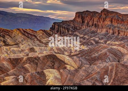 Eine malerische, farbenfrohe Wüstenszene mit stark erodierten Graten, aufgenommen am bekannten Zabriskie Point, Death Valley National Park, Kalifornien, USA Stockfoto