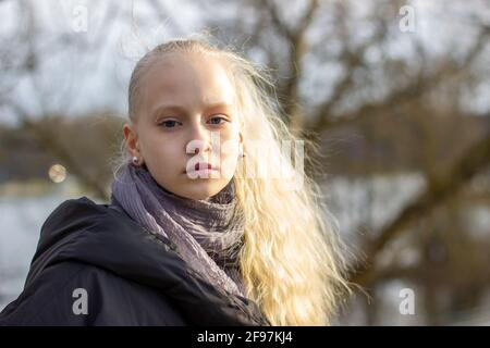 Porträt eines Teenagers mit blonden Haaren in einem frühen Frühlingspark. Hohe Qualität Stockfoto
