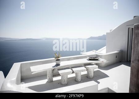 Ein weißer Balkon in Oia auf der Insel Santorini mit traditionellen kykladischen, weißen Häusern und Kirchen mit blauen Kuppeln über der Caldera, der Ägäis, Griechenland, Stockfoto
